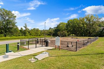 A dog park with a chain link fence and a sign